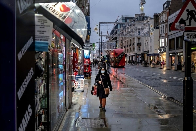 Người dân London đeo khẩu trang, đi lại trên đường phố vắng vẻ trong ngày đầu tiên thành phố áp đặt lệnh hạn chế cấp độ 3. Ảnh:NY Times